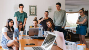 Content Produktion- Ein Team steht rund um einen Laptop