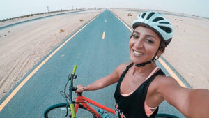 Influencer Radsportlerin steht mit Fahrrad auf einer Straße und macht ein Selfie- Influencer Marketing